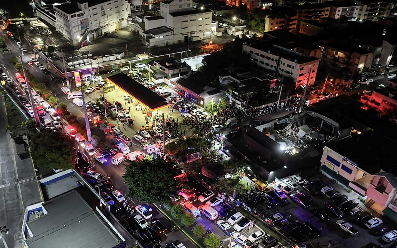 Aerial view of people gathering outside the Jet Set nightclub (R) after the collapse of its roof, in Santo Domingo, on April 8, 2025. At least 27 people were killed when the roof of a nightclub in the Dominican Republic collapsed early Tuesday morning, emergency services said, with rescue operations still underway. (Photo by Handout / Prensa Servicio 911 / AFP) / RESTRICTED TO EDITORIAL USE - MANDATORY CREDIT "AFP PHOTO / PRENSA SERVICIO 911"